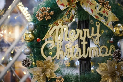 Close up gold Merry Christmas word at wreath with blur background