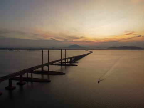 Aerial view morning sunrise of Penang Bridge. Fisherman boat sail at sea