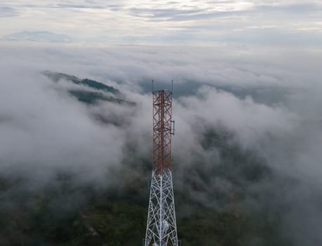 Aerial view telecommunication tower in misty forest