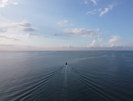 Aerial view fishing boat move at sea in blue sunny day