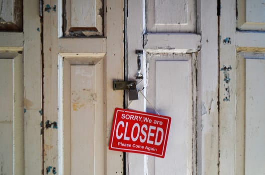 Sorry, We are Closed, Please Come Again sign at wooden door