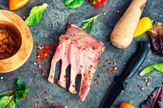 Appetizing raw lamb rib and spices on the kitchen table. Uncooked meat lamb