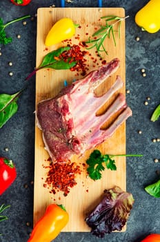 Appetizing raw lamb rib and spices on the kitchen table. Uncooked meat lamb