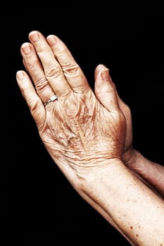 An old woman in prayer. Praying hands of an old woman