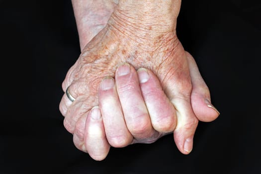 A helping hand in old age. The hands of two old women