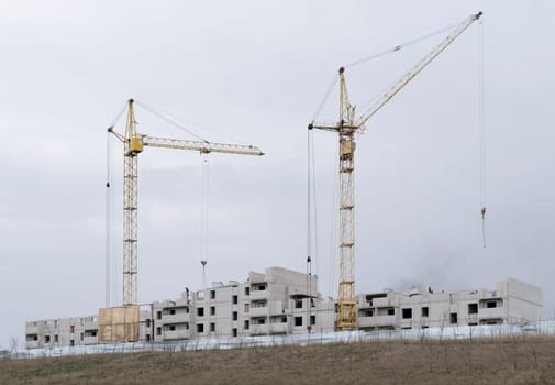 Construction of a new high-rise building. Two tower cranes