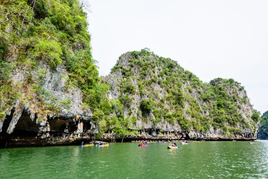 PHANG NGA, THAILAND - APRIL 27 2015: Tourists are happy with the canoeing near island on the sea surface at Tham Lod cave in Ao Phang Nga Bay National Park, APRIL 27 2015 in Thailand
