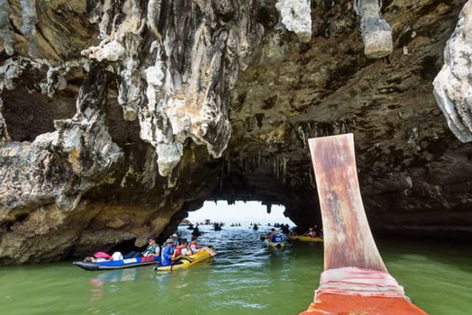 PHANG NGA, THAILAND - APRIL 27 2015: Happy tourists on canoe through the caves of the island on the sea surface at Tham Lod cave in Ao Phang Nga Bay National Park, APRIL 27 2015 in Thailand