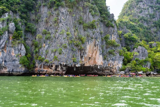 PHANG NGA, THAILAND - APRIL 27 2015: Tourists are happy with the canoeing near island on the sea surface at Tham Lod cave in Ao Phang Nga Bay National Park, APRIL 27 2015 in Thailand