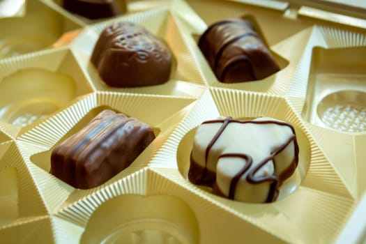 Various chocolates in an elegant chocolate box, close up, sharpness in the lower left corner of the photo