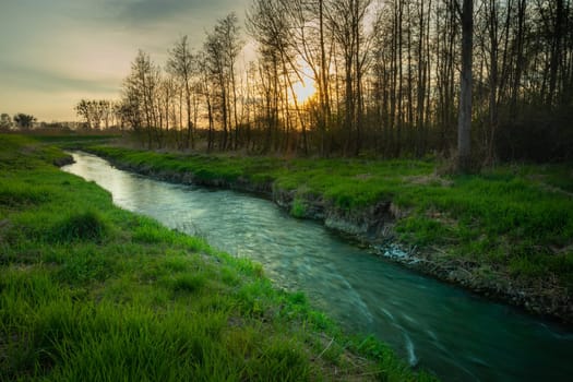 A small river and sunset behind the trees, Stankow, Poland