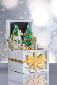 Christmas card. Old wooden music box with a christmas song on a table over abstract bright background. The Christmas tree and the figures are moving. Clipping path. Christmas tree music box.