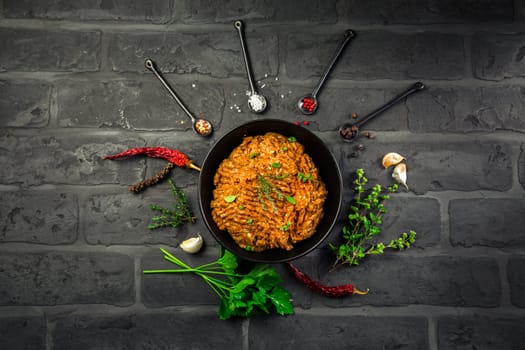 Mince. Marinated Ground meat with ingredients for cooking on black background. Top view