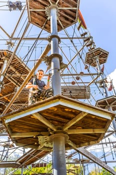 Child climbing in the high ropes course. Sport and adventure concept.