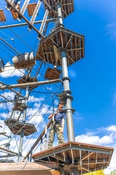 Child climbing in the high ropes course. Sport and adventure concept.