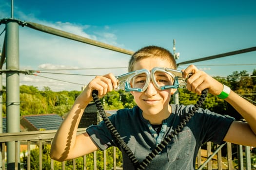 Zipline equipment for safety,  adventure in  high ropes course.  Happy boy reached highest platform.
