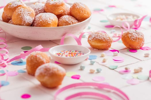 Traditional Berliner for carnival and party. German Krapfen or donuts with streamers and confetti. Colorful carnival or birthday image