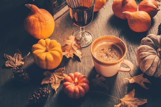 Cozy autumn composition. Hot cocoa with autumn leaves and pumpkins on kitchen table