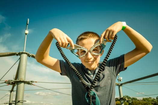 Zipline equipment for safety,  adventure in  high ropes course.  Happy boy reached highest platform.