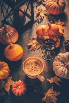 Cozy autumn composition. Hot cocoa with autumn leaves and pumpkins on kitchen table