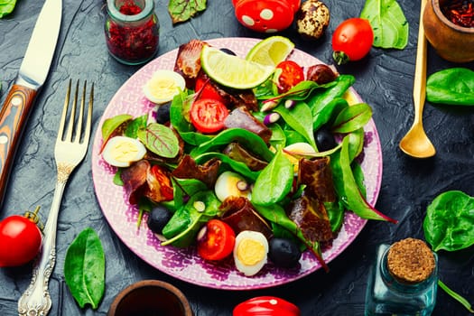 Appetizing salad with fresh herbs, raw vegetables and bacon