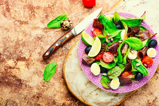 Appetizing salad with fresh herbs, raw vegetables and bacon