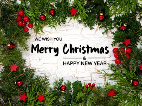 Christmas Card With Fir Branches And English Text Merry Christmas And A Happy New Year. White Wooden Background With Vintage Design, Christmas Decoration Like Red Ornament Balls.