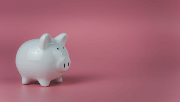 white piggy bank on a pink background. Savings and investment concepts.