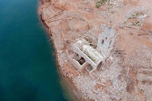Aerial view of Sau Reservoir, in the Ter River, in the Province of Girona, Catalonia, Spain. After months without rain the level of the swamp is very low. Detail of the church of Sant Roma cenital