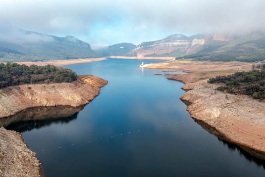 Aerial view of Sau Reservoir, in the Ter River, in the Province of Girona, Catalonia, Spain. After months without rain the level of the swamp is very low.