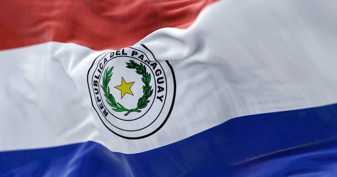 Close-up view of the Paraguay national flag waving in the wind. The Republic of Paraguay is a State of South America. Fabric textured background. Selective focus