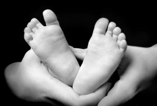 Mother's hands holdning hers son's feet