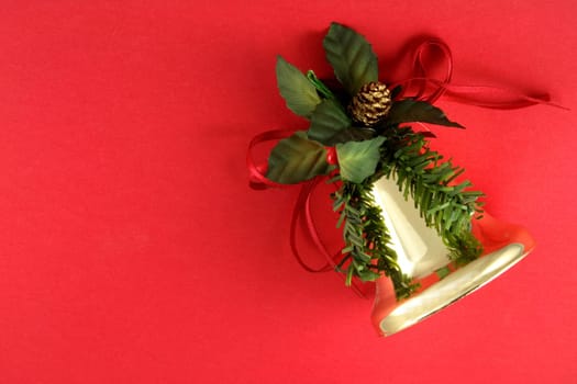 Christmas bell ornament on a red background.
