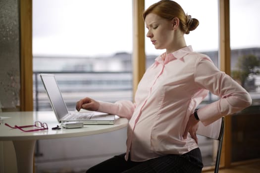 pregnant business woman sitting at her desk
