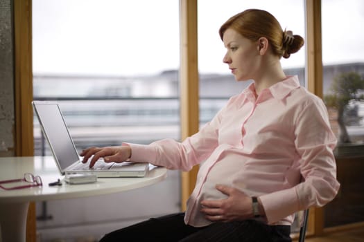 pregnant business woman at her desk