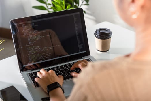 Programmer woman writing program HTML code sitting at workplace in office, IT software developer hands typing data coding programming with laptop computer, IT start up concept, Web application design