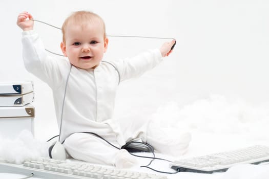 little baby playing with two computer keyboards and mouse