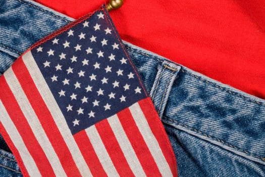A small American flag against a pair of blue jeans and a t-shirt