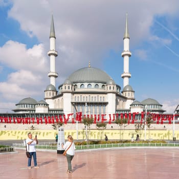 Istanbul, Turkey - September 2 2022: Tourists taking photos in front of Taksim Mosque, at Taksim Square, Beyoglu district, central Istanbul, in a sunny summer day