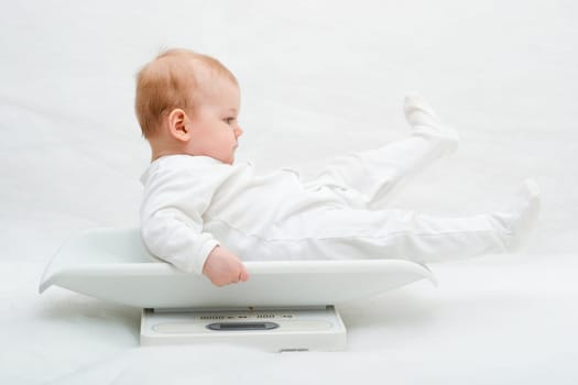 baby on scales on white background, with copy space