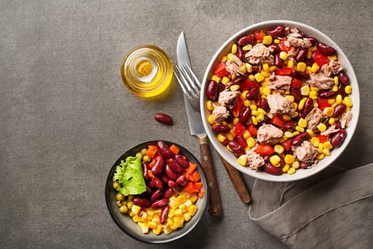 Healthy tuna salad with corn, peppers and beans on grey background. Mexican corn salad.