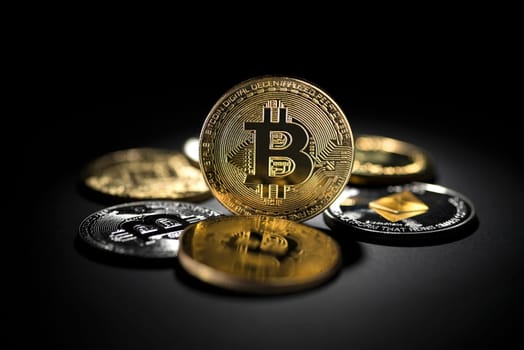 Bitcoin coins and altcoins in black background. Virtual cryptocurrency concept.