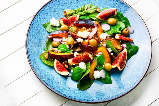 Unusual salad with figs, plums, herbs and olives. Natural salad