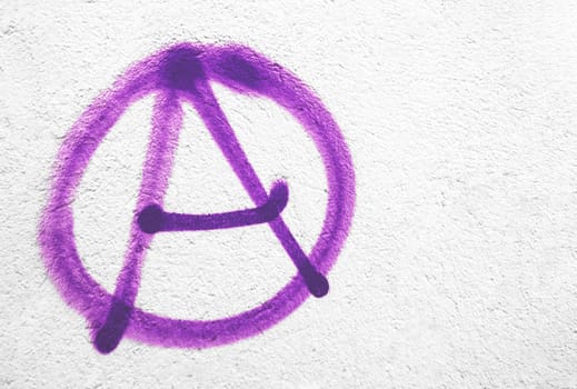 Violet anarchy symbol on wall. Ideal for textures, backgrounds and concepts. Copy space.