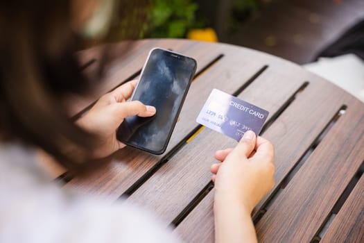 Close up hand of woman using credit card and smartphone during slide screen for finding product purchase buying payments online shopping, making secure internet payment browsing banking service