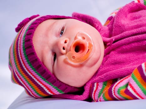 A portrait of a baby girl in a pink shirt.