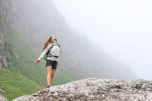 Hiker relaxing breathing fresh air in a foggy mountain