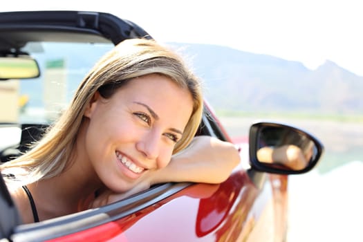 Happy convertible car driver smiling and resting looking away