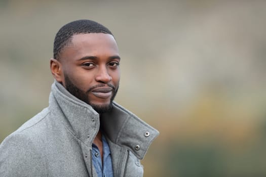 Confident black man looks at you in a park