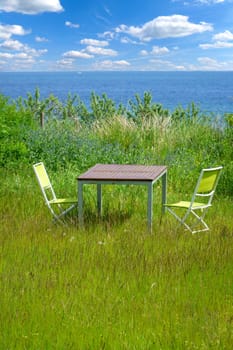 Garden furniture on green lawn with views of the Baltic Sea